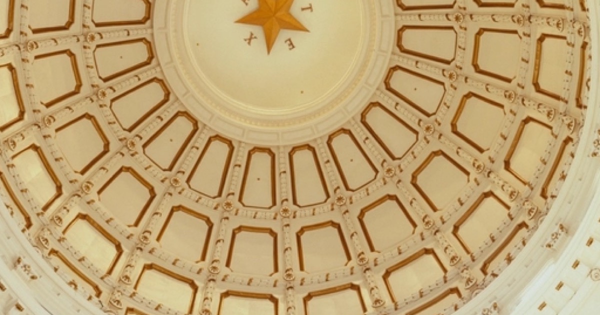 The ornate rotunda ceiling of the Texas State Capitol seen from the floor below